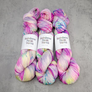 Roseate - Hand Dyed Super Sock, Fingering Weight 75/25 Merino Nylon Yarn, UV Reactive Pink Cream Multi Speckled, 463 Yards (423 Meters)